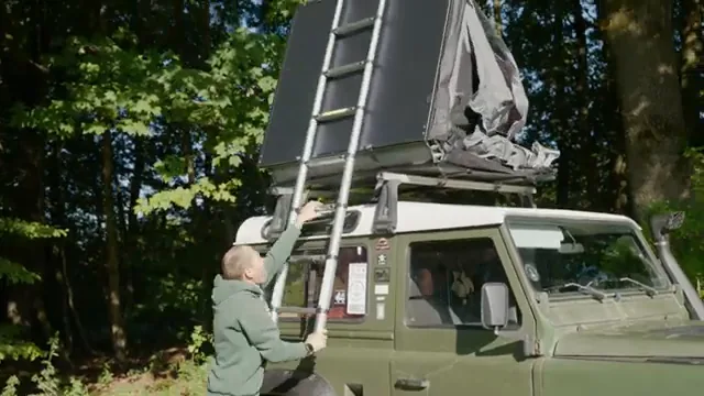 Outwell roof tent on a vehicle at a woodland campsite